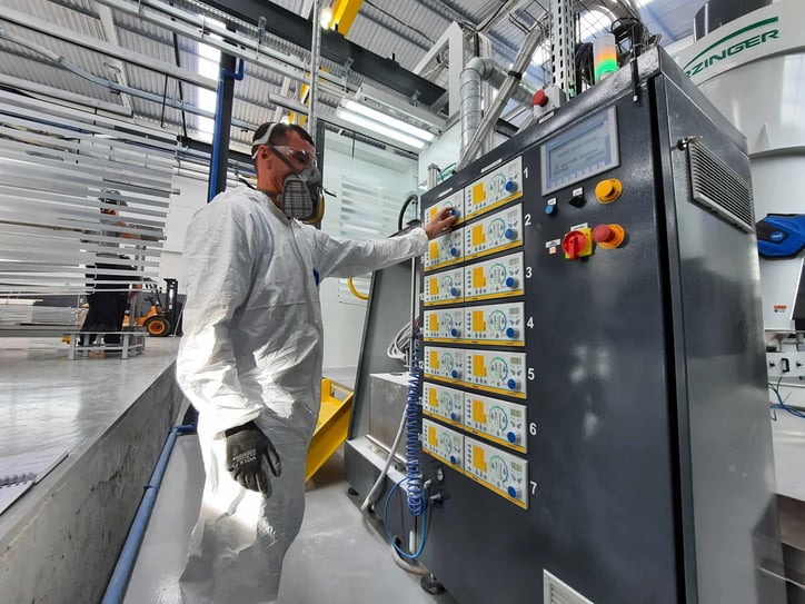 El operario realiza algunos ajustes en las pistolas de control de la línea de pintura en polvo.
